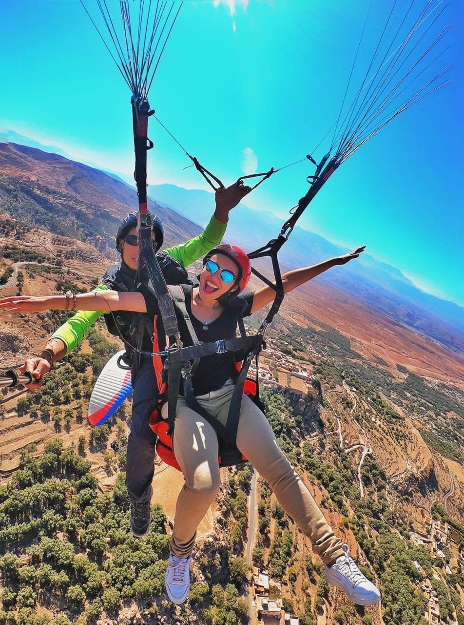 Paragliding pilot and traveler preparing for launch in the Atlas Mountains.